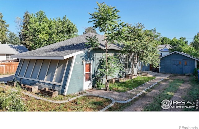 143 W 10th St, Loveland, CO 80537 - bungalow-style home featuring roof with shingles and a storage unit