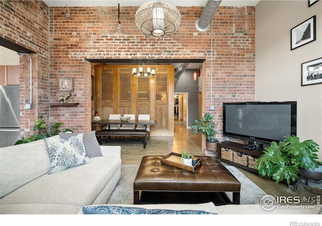 2500 Walnut St Unit 201, Denver, CO 80205 - living area with a chandelier, a high ceiling, and brick wall
