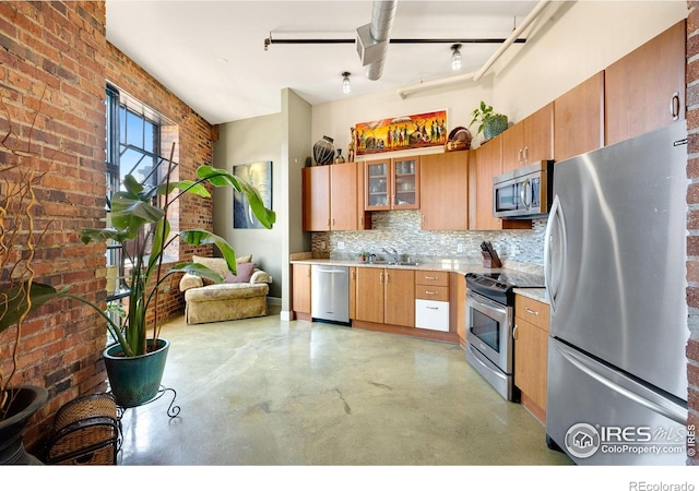 2500 Walnut St Unit 201, Denver, CO 80205 - kitchen featuring appliances with stainless steel finishes, finished concrete floors, brick wall, light countertops, and tasteful backsplash