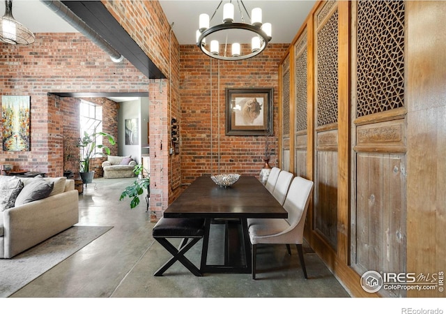2500 Walnut St Unit 201, Denver, CO 80205 - dining area featuring brick wall, finished concrete floors, and a chandelier