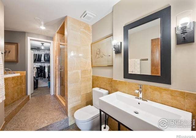 2500 Walnut St Unit 201, Denver, CO 80205 - bathroom with tile walls, a stall shower, a spacious closet, and tile patterned floors