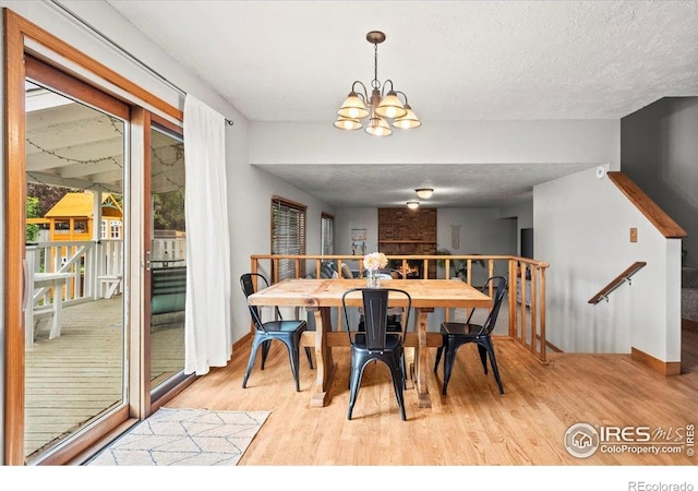 4324 W 22nd St, Greeley, CO 80634 - dining space with light wood finished floors, a chandelier, and a textured ceiling