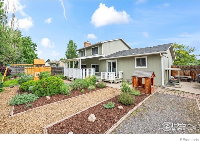 4324 W 22nd St, Greeley, CO 80634 - view of front of house featuring a chimney, a deck, a playground, and a patio
