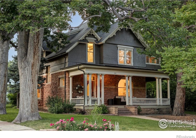 505 Pine St, Boulder, CO 80302 - view of front of house featuring covered porch, stone siding, and a front yard