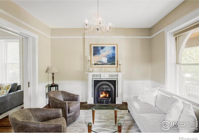 505 Pine St, Boulder, CO 80302 - living room featuring a chandelier, wainscoting, a lit fireplace, plenty of natural light, and wood finished floors