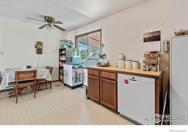 2110 Charro Ave, Longmont, CO 80504 - kitchen with white dishwasher, a ceiling fan, stainless steel microwave, brown cabinetry, and light countertops