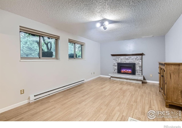 2912 Worthington Ave, Fort Collins, CO 80526 - unfurnished living room with a baseboard radiator, light wood-type flooring, a textured ceiling, and a stone fireplace