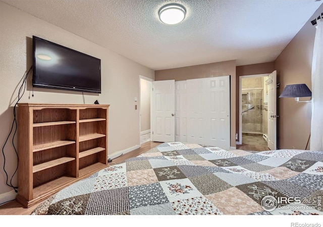2912 Worthington Ave, Fort Collins, CO 80526 - bedroom featuring a textured ceiling, a closet, ensuite bathroom, and wood finished floors