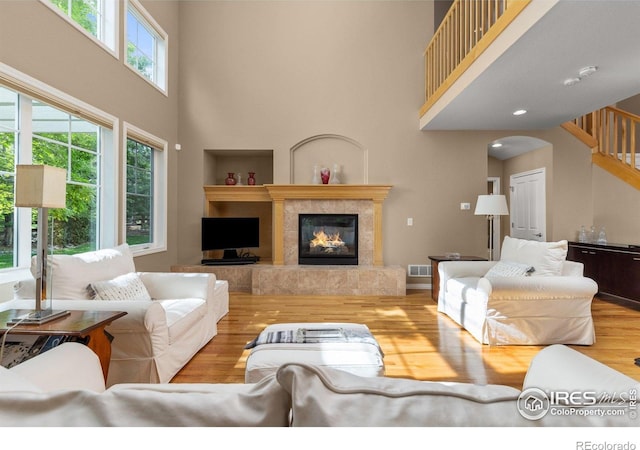 1231 Hawk Ridge Rd, Lafayette, CO 80026 - living room with a high ceiling, a fireplace, wood finished floors, stairway, and arched walkways