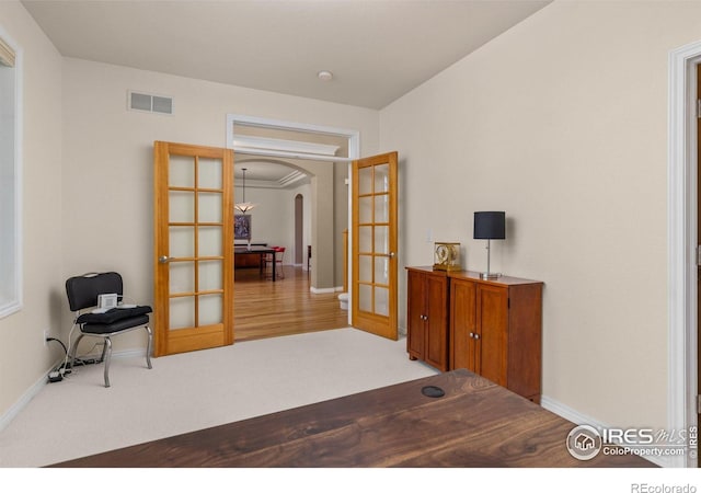 1231 Hawk Ridge Rd, Lafayette, CO 80026 - living area featuring french doors, arched walkways, and light carpet