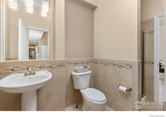 1231 Hawk Ridge Rd, Lafayette, CO 80026 - full bathroom featuring tile walls, a stall shower, and a wainscoted wall