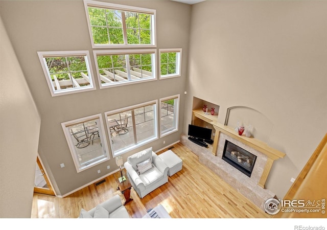 1231 Hawk Ridge Rd, Lafayette, CO 80026 - living area featuring a high end fireplace, wood finished floors, and a towering ceiling