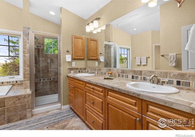 1231 Hawk Ridge Rd, Lafayette, CO 80026 - full bath featuring lofted ceiling, a stall shower, double vanity, a garden tub, and tile patterned flooring