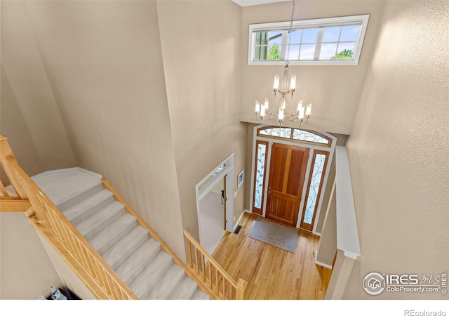 1231 Hawk Ridge Rd, Lafayette, CO 80026 - foyer featuring wood finished floors, a chandelier, and stairs