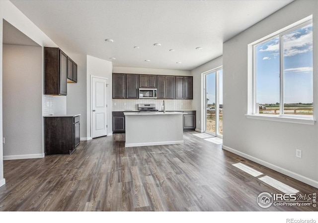 850 Mesic Ln, Windsor, CO 80550 - kitchen featuring stainless steel appliances, dark brown cabinetry, backsplash, light countertops, and dark wood-style flooring