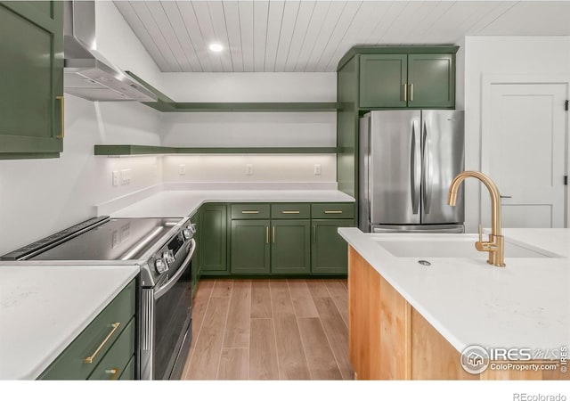 2009 18th Ave, Greeley, CO 80631 - kitchen with green cabinets, appliances with stainless steel finishes, ventilation hood, light wood-type flooring, and light countertops