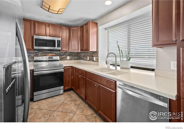 7414 Benton St, Arvada, CO 80003 - kitchen with stainless steel appliances, light countertops, backsplash, and brown cabinets