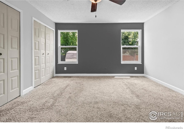 7414 Benton St, Arvada, CO 80003 - unfurnished bedroom featuring carpet flooring, a textured ceiling, multiple closets, and ceiling fan