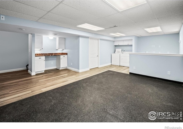 7414 Benton St, Arvada, CO 80003 - finished below grade area with washing machine and clothes dryer, a paneled ceiling, wood finished floors, and a desk