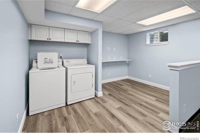 7414 Benton St, Arvada, CO 80003 - washroom with washing machine and dryer, light wood finished floors, and cabinet space