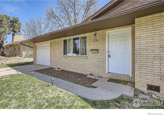 1036 Meadowbrook Dr, Fort Collins, CO 80521 - doorway to property with brick siding, concrete driveway, and a garage
