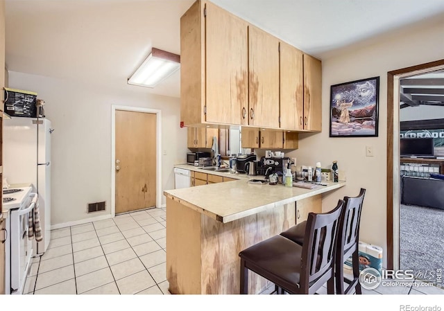 1036 Meadowbrook Dr, Fort Collins, CO 80521 - kitchen featuring white appliances, light countertops, a peninsula, a breakfast bar, and light tile patterned flooring