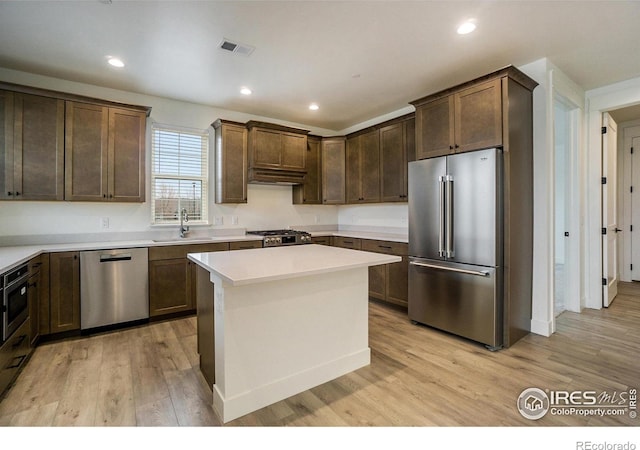 3045 E Trilby Rd Unit B-10, Fort Collins, CO 80528 - kitchen featuring stainless steel appliances, light countertops, light wood finished floors, dark brown cabinets, and a kitchen island
