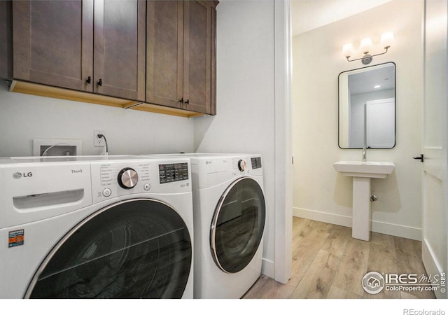 3045 E Trilby Rd Unit B-10, Fort Collins, CO 80528 - laundry room with washing machine and clothes dryer, light wood-type flooring, and cabinet space