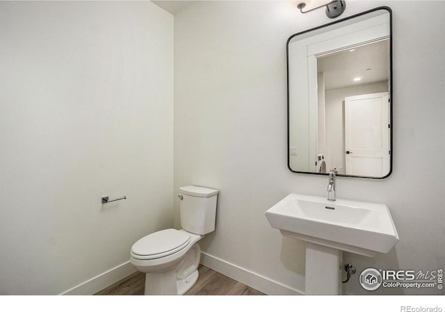 3045 E Trilby Rd Unit B-10, Fort Collins, CO 80528 - half bathroom featuring baseboards and wood finished floors