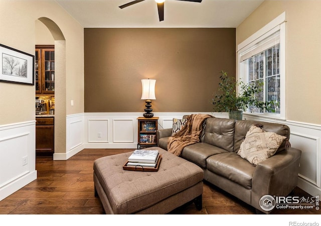 1963 Blue Yonder Way, Fort Collins, CO 80525 - living room featuring a wainscoted wall, ceiling fan, dark wood finished floors, arched walkways, and a decorative wall