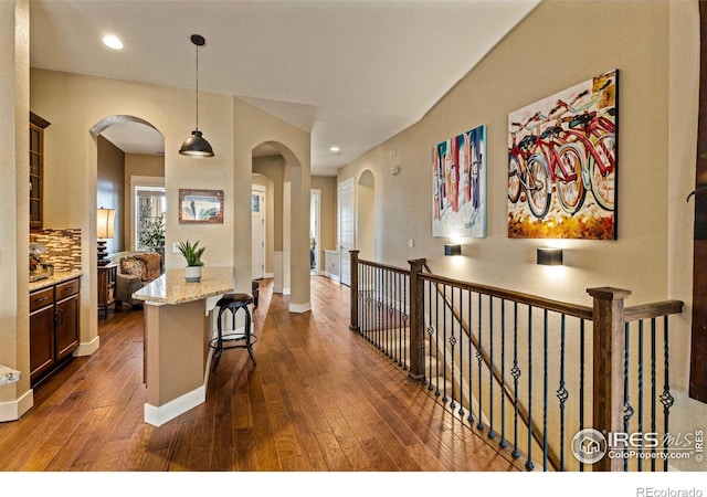 1963 Blue Yonder Way, Fort Collins, CO 80525 - hallway with arched walkways, dark wood-type flooring, recessed lighting, and an upstairs landing