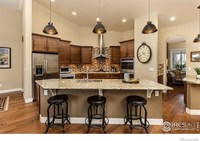 1963 Blue Yonder Way, Fort Collins, CO 80525 - kitchen with appliances with stainless steel finishes, backsplash, arched walkways, dark wood-style floors, and recessed lighting