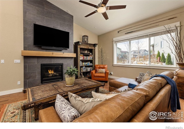1963 Blue Yonder Way, Fort Collins, CO 80525 - living area featuring lofted ceiling, a ceiling fan, wood finished floors, and a tile fireplace