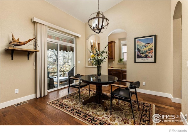 1963 Blue Yonder Way, Fort Collins, CO 80525 - dining space featuring arched walkways, a chandelier, vaulted ceiling, and dark wood-style flooring