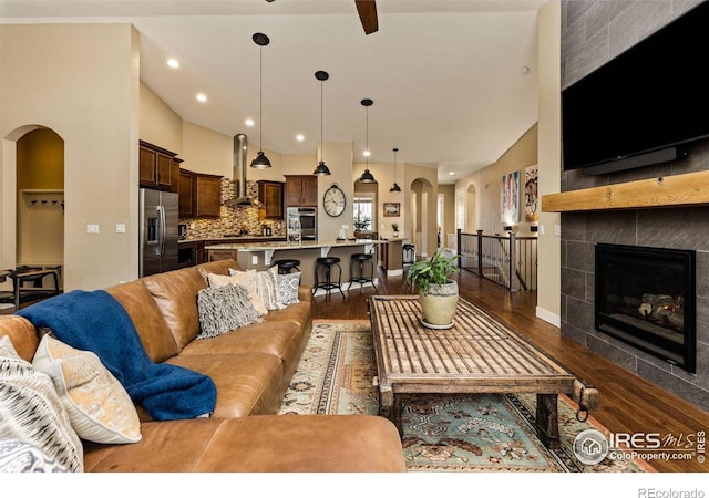 1963 Blue Yonder Way, Fort Collins, CO 80525 - living area featuring arched walkways, dark wood-style floors, a fireplace, recessed lighting, and a ceiling fan