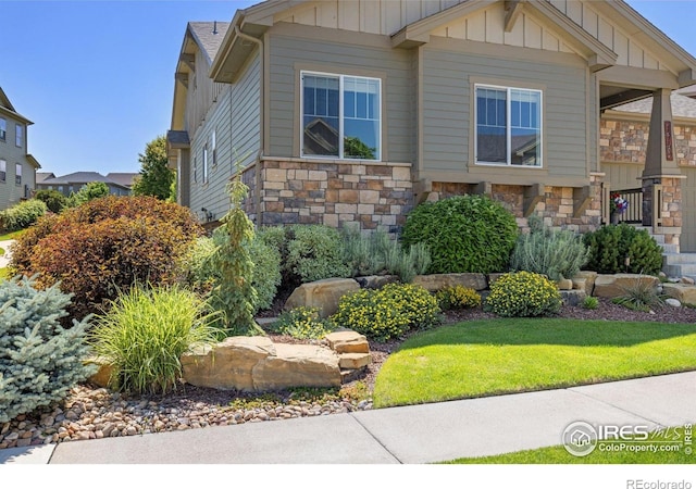 1963 Blue Yonder Way, Fort Collins, CO 80525 - view of front of home with board and batten siding, stone siding, and a front yard