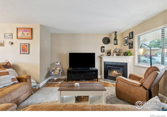 1607 Rushmore Dr, Colorado Springs, CO 80910 - living room featuring wood finished floors, a glass covered fireplace, and a textured ceiling