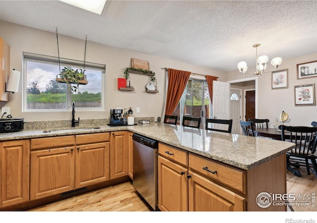 1607 Rushmore Dr, Colorado Springs, CO 80910 - kitchen with dishwasher, a peninsula, light wood-type flooring, a chandelier, and light stone counters