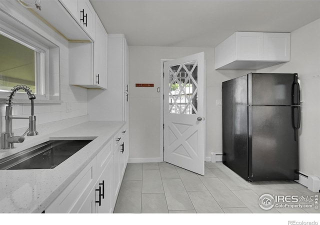 707 E Emma St, Lafayette, CO 80026 - kitchen featuring freestanding refrigerator, light tile patterned floors, baseboard heating, and white cabinets