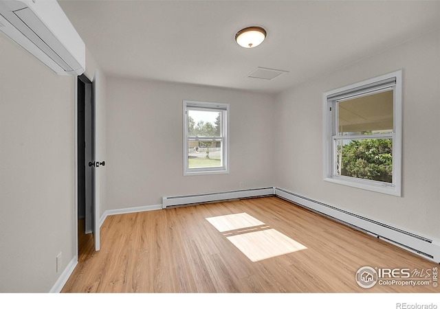 707 E Emma St, Lafayette, CO 80026 - spare room with a baseboard heating unit, a wall unit AC, baseboard heating, and wood finished floors