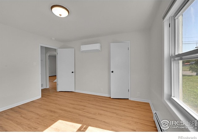707 E Emma St, Lafayette, CO 80026 - unfurnished room with a wall mounted AC, plenty of natural light, light wood finished floors, and a baseboard radiator
