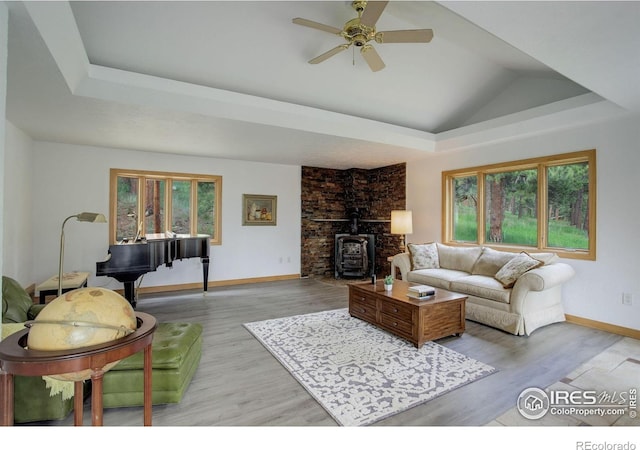 849 Mountain Meadows Rd, Boulder, CO 80302 - living area with a tray ceiling, ceiling fan, wood finished floors, and a wood stove
