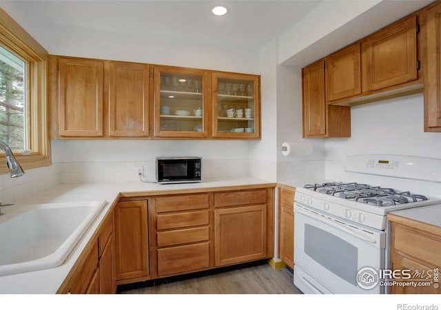 849 Mountain Meadows Rd, Boulder, CO 80302 - kitchen featuring white range with gas stovetop, black microwave, light countertops, glass insert cabinets, and recessed lighting