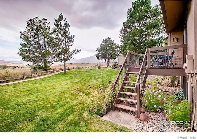 1624 Bradley Ct, Boulder, CO 80305 - view of grassy yard with stairway, a deck with mountain view, and a view of rural / pastoral area