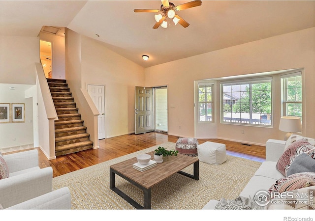 3228 Borrossa St, Evans, CO 80634 - living area featuring wood finished floors, a ceiling fan, stairway, and high vaulted ceiling