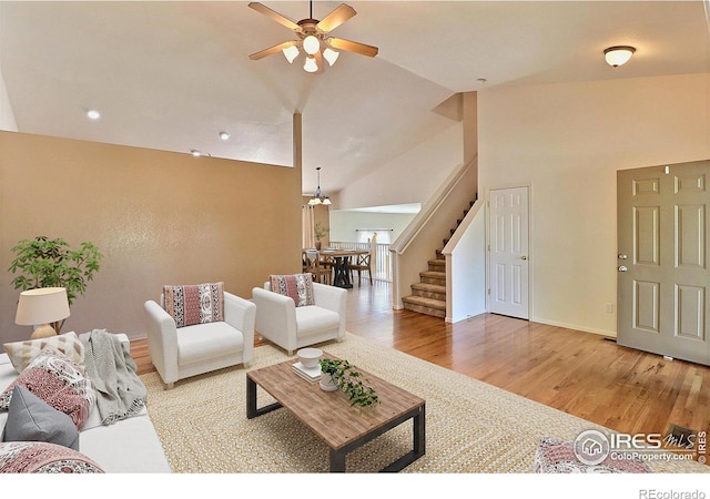 3228 Borrossa St, Evans, CO 80634 - living room featuring ceiling fan, wood finished floors, stairs, vaulted ceiling, and recessed lighting