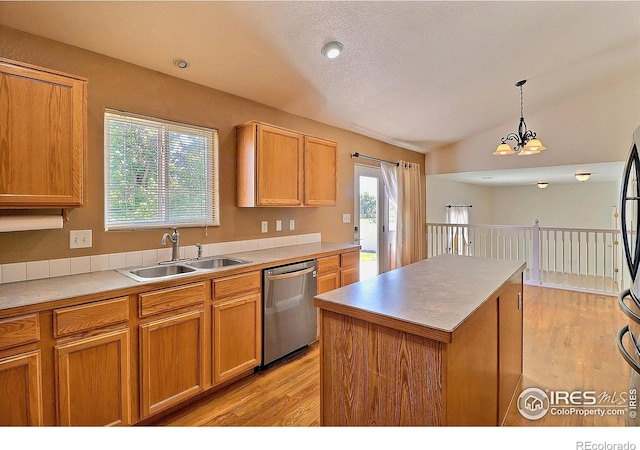 3228 Borrossa St, Evans, CO 80634 - kitchen with stainless steel dishwasher, light wood-style floors, lofted ceiling, a kitchen island, and pendant lighting