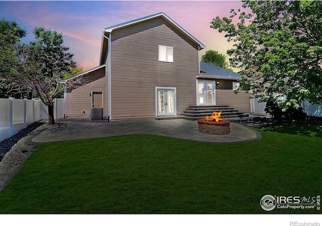3228 Borrossa St, Evans, CO 80634 - back of house at dusk with a fire pit, a patio, and a fenced backyard