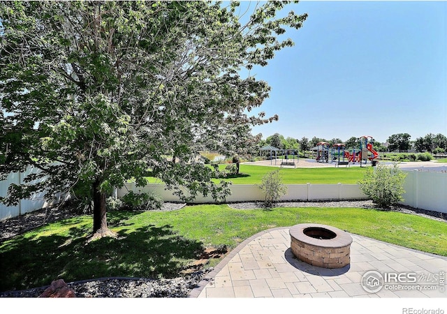 3228 Borrossa St, Evans, CO 80634 - fenced backyard featuring a fire pit, a playground, and a patio