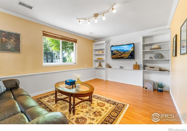 109 Sunflower Dr, Windsor, CO 80550 - living area with wood finished floors, a wainscoted wall, ornamental molding, and built in features